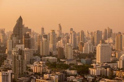 Aerial view of buildings in city against sky during sunset