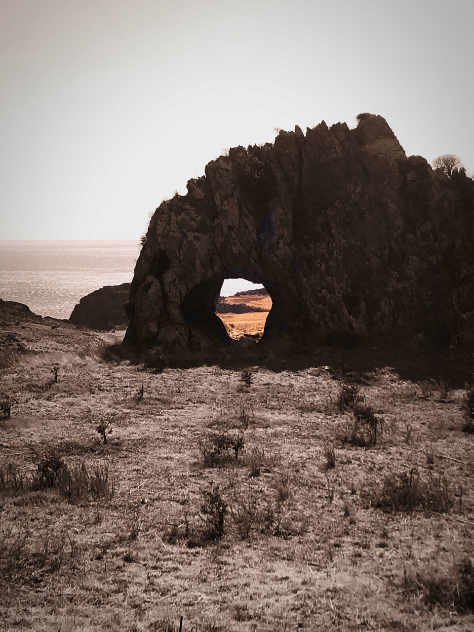 ROCK FORMATIONS ON SHORE AGAINST CLEAR SKY