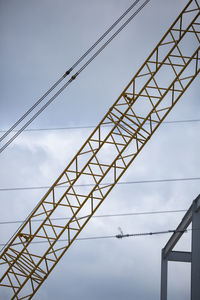 Low angle view of crane against sky