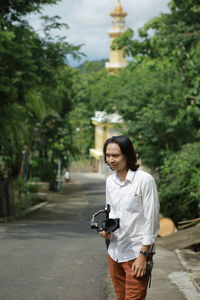 Full length of woman standing on sidewalk in city