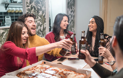 Young friends toasting on table