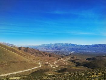 Scenic view of landscape and mountains against blue sky