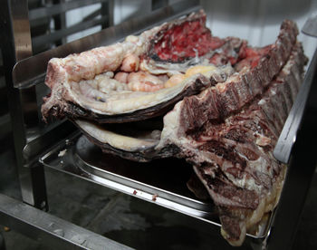 Close-up of meat on metallic rack in kitchen