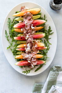 Slices of watermelon, cantaloupe and cucumber topped with prosciutto and feta.