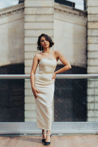 Young woman standing against wall