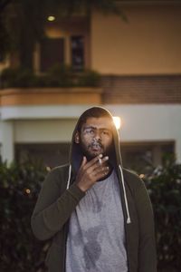 Portrait of man holding camera at night