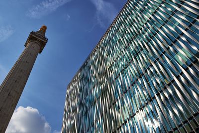 Low angle view of skyscrapers against cloudy sky