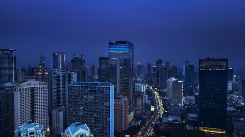 Illuminated cityscape against sky at night