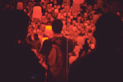 Rear view of people standing at night