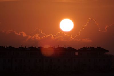 Silhouette buildings against sky during sunset
