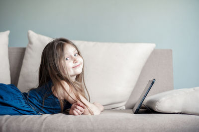 Woman lying down on sofa at home