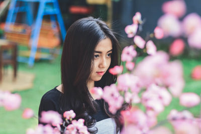 Portrait of woman with pink flower