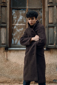 Young woman standing against wall