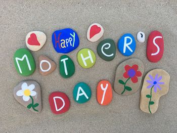 High angle view of multi colored pebbles with text at beach