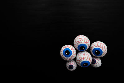 Funny halloween treat - candy eyeballs on dark background. copy space