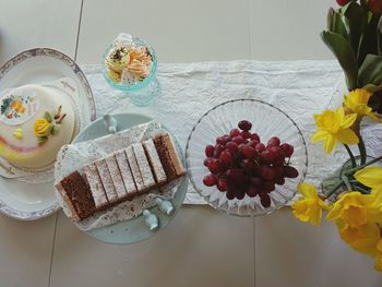 High angle view of various cakes and fruit in plate on table