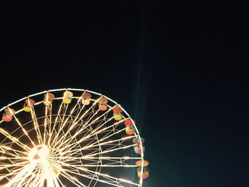 Low angle view of illuminated ferris wheel against sky at night