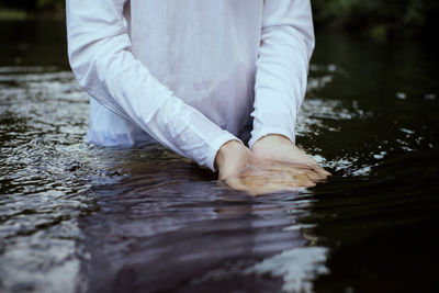 Midsection of man standing in water