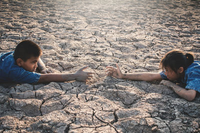 Children gesturing on barren land