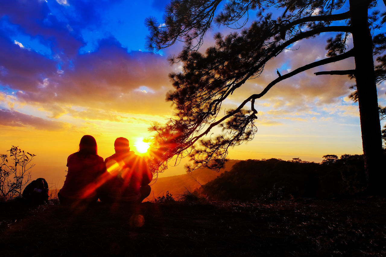 SILHOUETTE PEOPLE SITTING ON LAND DURING SUNSET