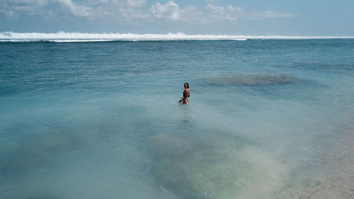 Aerial view of woman standing in sea