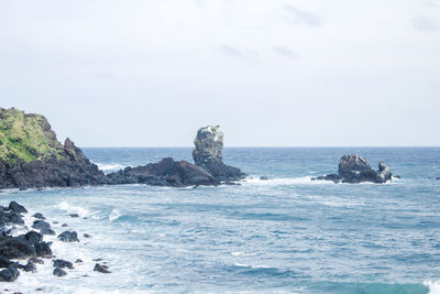 Scenic view of rocks in sea against sky