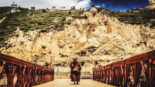 Woman standing on bridge against sky