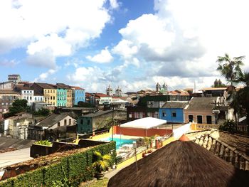 Houses in town against cloudy sky
