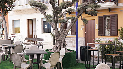 Empty chairs and tables at sidewalk cafe