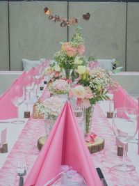 Pink flowering plants on table against building