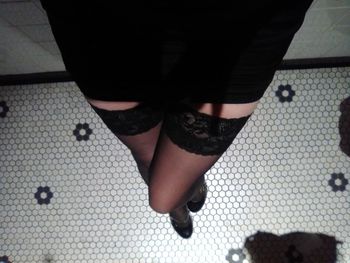 Low section of woman standing on tiled floor