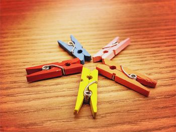 High angle view of multi colored clothespins on wooden table