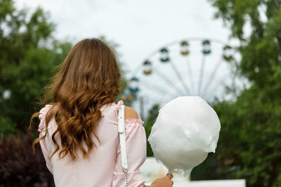 Rear view of woman holding cotton candy
