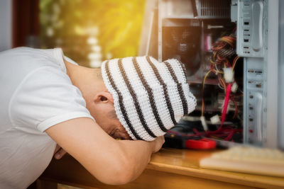 Side view of man napping on table