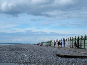 People at beach against sky