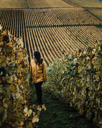 Rear view of woman standing on farm