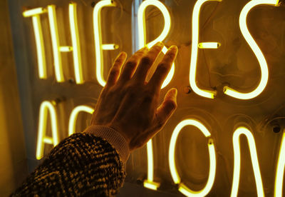 Close-up of hand holding illuminated text at night