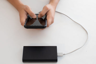 Midsection of man using smart phone on table