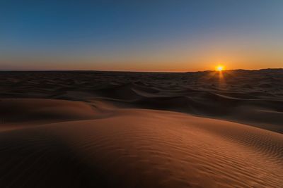 Scenic view of desert against sky during sunset