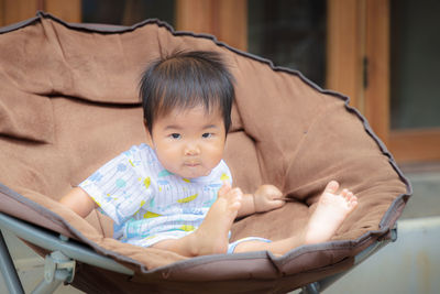 Portrait of cute baby girl sitting at home