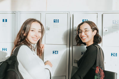 Portrait of smiling female friends standing in office