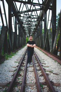 Portrait of young man standing on railroad track