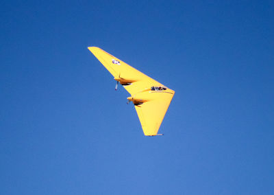 Low angle view of airplane flying against blue sky