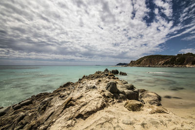 Scenic view of rocks on beach against sky