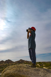 Full length of man standing on mountain against sky