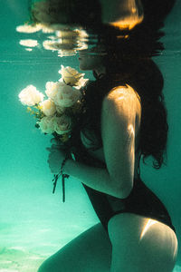 Rear view of woman swimming in sea