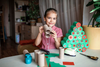 Portrait of girl preparing christmas decoration at home