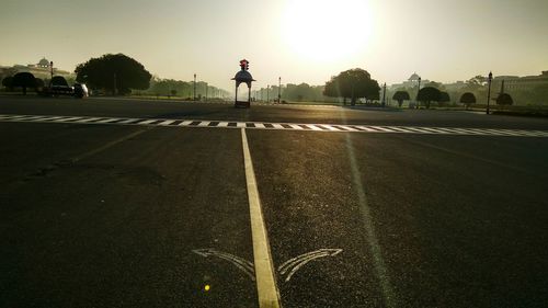 Man on road in city against sky during sunset