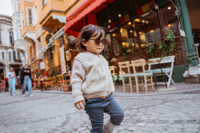 Portrait of young woman standing in city