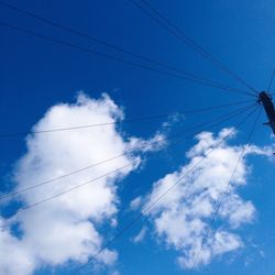 Low angle view of birds flying against blue sky